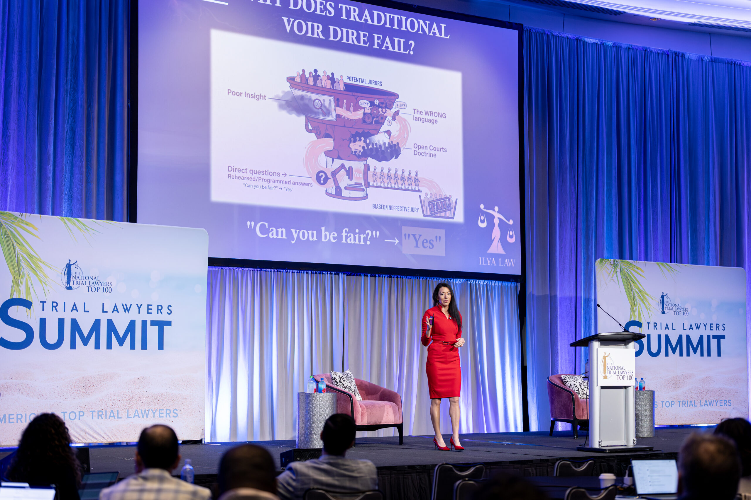 Speaker presenting on stage to an audience during The National Trial Lawyers Summit.